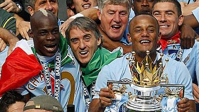 Roberto Mancini, centre, with the Manchester City captain, Vincent Kompany, right, hailed CIty's triumph as a crazy end to a crazy season.