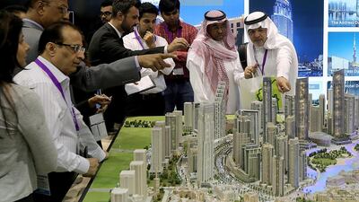 Visitors look at scaled versions of Emaar's Downtown Dubai projects at the opening day of Cityscape Global. Satish Kumar / The National