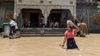 A woman wades through a flooded street in Wetlet, in Myanmar's Sagaing region. AFP
