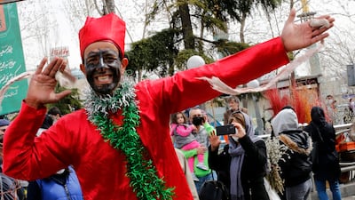 An Iranian man dressed as Haji Firuz, the traditional herald of Nowruz, the Persian New Year, dances and collects money among the people shopping at a street market for the festivities, in Tehran. Traditionally, Iranians buy goldfish and flowers to mark Nowruz, which this year falls on March 20. EPA