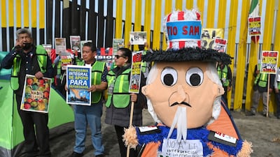 Migrants and activists demonstrate on the need for migrant rights at the US-Mexico border in Tijuana, Mexico, on December 18. Bloomberg