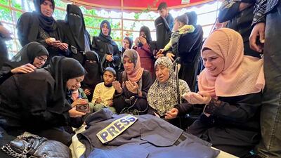 Relatives over the body of journalist Ahmed Mansour at Nasser Medical Complex in Khan Younis in southern Gaza, on April 8, 2025. AFP