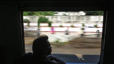 A passenger looks out of a window of a northern line train traveling from Bangkok to Den Chai. Dario Pignatelli / Bloomberg News
