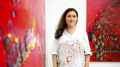 The Saudi Arabian painter Hadil Moufti in her studio in the Al Fahidi neighbourhood of Dubai, with two of her works based on a photo of her niece. Lee Hoagland/The National