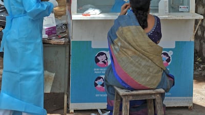 A health worker collects a swab sample of a woman at a government free testing centre in Hyderabad on July 17, 2020. AFP