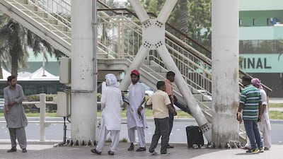 Passengers wait near Abu Dhabi Bus Terminal. Readers say that illegal taxis and minibuses should be incorporated into the public transport mix to benefit low-wage earners. Mona Al Marzooqi / The National