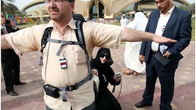 Zeinab al Husari searches for nuclear materials on Ahmed Sallam during a demonstration in Abu Dhabi yesterday.
