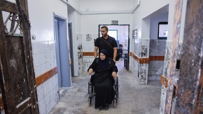 A man accompanies a patient arriving for treatment at Al-Shifa hospital's dialysis center after its rehabilitation. AFP