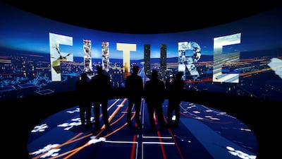 Visitors watch a 3D presentation during an exhibition about Neom City which is being built in Saudi Arabia. Photo: Reuters