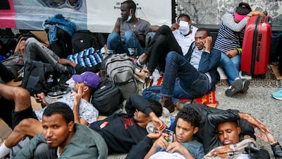A group of migrants rest outside the former Roosevelt Hotel. EPA-EFE