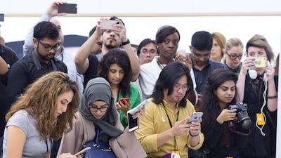 Media delegates use their iPhones at the the preview of the Apple Store in Mall of the Emirates. Reem Mohammed / The National