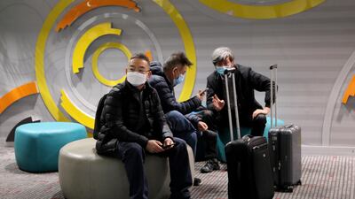 Travellers sit at Beijing Capital International Airport in Beijing, China. Reuters
