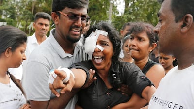 A woman who lost her husband and two children during the bombing at St Sebastian's Church yells towards their graves during a mass burial for victims at a cemetery near the church in Negombo. Reuters
