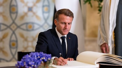 Mr Macron signs the guest book during the reception. UAE Presidential Court