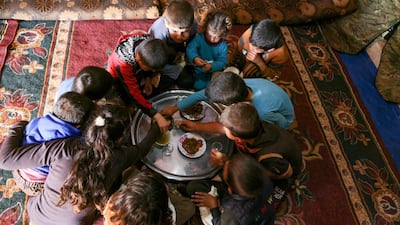 Some of Abderrazaq Khatoun's grandchildren share a meal. AFP