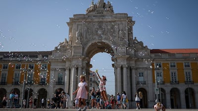 Children play with bubbles in Praca do Comercio, Lisbon. AFP