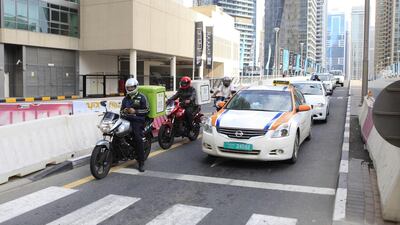 Food-delivery motorcyclists weave through Dubai traffic. Sarah Dea / The National, file