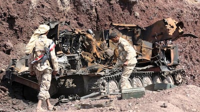 Soldiers loyal to Yemen's government stand next to an damaged armoured vehicle at the frontline of fighting against Houthi militants in the central province of Marib on October 6. Reuters