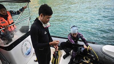 Thai marine researchers prepare a dive to inspect corals in Chonburi district
