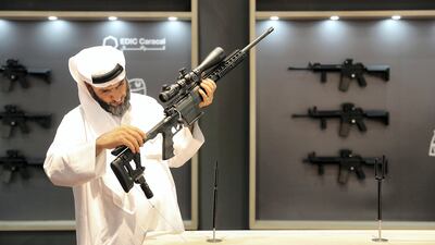 A visitor looks at guns at the Caracal stand on the first day of the Adihex. Pawan Singh / The National