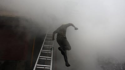 A firefighter jumps from a ladder during a fire in downtown Srinagar. Danish Ismail / Reuters