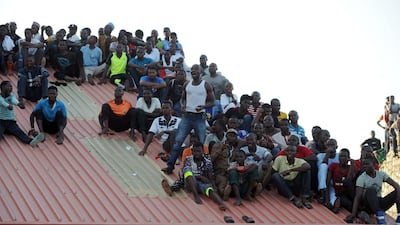 Supporters sit on the roof of a house to watch the African Cup of Nations qualification match between Egypt and Nigeria, on March 25, 2016, in Kaduna. AFP / PIUS UTOMI EKPEI