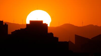 The sun is partially eclipsed as it sets over the horizon in Beijing. AP Photo