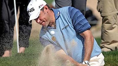Lee Westwood of Britain hits out of a bunker on the fifth green during the second round in Doha.