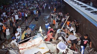 Rescue workers and residents pull free a victim of the train crash in Pemalang, Central Java, Indonesia.