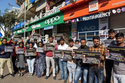 Mobile dealers and members of Ahmedabad Mobile Dealer's Association hold placards as they protest against online shopping platform Amazon outside their closed mobile shops in Ahmedabad on January 15. AFP
