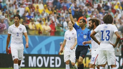 Omar Gonzalez of the US receives a yellow card from referee Ravshan Irmatov for fouling Germany's Bastian Schweinsteiger, ground, during their match on Thursday at the 2014 World Cup. Yves Herman / Reuters