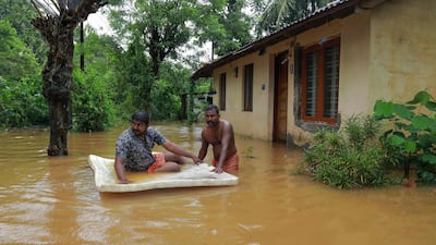 Men pass through flood waters at Eloor area in Ernakulam district. AFP