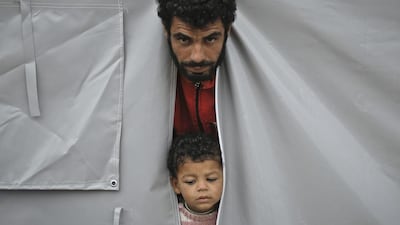 Syrian Kurdish refugees from Kobani, peer from a tent at a refugee camp in Suruc, near the Turkey-Syria border. Kobani, also known as Ayn Arab, and its surrounding areas, has been under assault by extremists of the Islamic State group since mid-September and is being defended by Kurdish fighters. Vadim Ghirda / AP Photo