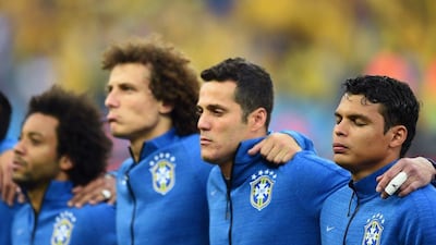 David Luiz, second from left, and Thiago Silva, far right, shown during the singing of the national anthem before Brazil's World Cup opener on Thursday. Christopher Lee / Getty Images / June 12, 2014