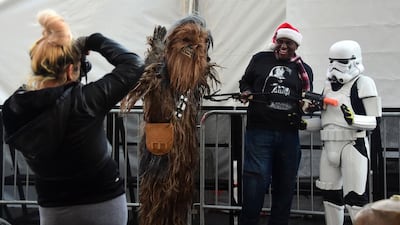 Star Wars fans dressed as Chewbacca and a Stormtrooper pose for a photo with a man in a Santa hat along Hollywood Boulevard in Hollywood, California, in front of the large white tent lining the street for the premiere of the latest Star Wars film, The Force Awakens. Frederic J Brown / AFP photo