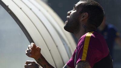Barcelona’s Brazilian defender Dani Alves plays with a ball as he arrives for a training session at the FC Barcelona Joan Gamper Sports Centre in Sant Joan Despi, near Barcelona on April 16, 2015, on the eve of the La Liga match FC Barcelona v Valencia CF. AFP / LLUIS GENE