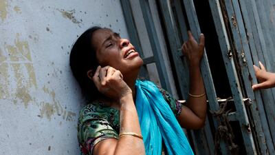 A woman cries as she talks on a telephone following the building collapse. EPA /Abir Abdullah