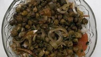 Chana Chaat consisting of red lentils, green and red chillies, onions and tomatoes.