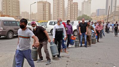 People queue in front of a shop to refill their gas cylinders in Kuwait City, a day after Kuwaiti authorities announced a 20-day total lockdown to tackle the Covid-19 pandemic. AFP