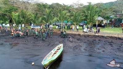 A clean-up crew works at a site polluted by leaked oil.