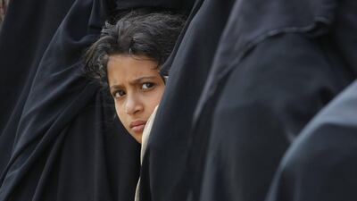 A young Yemeni girl waits among the crush of women lining up to receive free bread at a charity bakery during a severe shortage of food in Sanaa on August 15, 2017. Yahya Arhab / EPA