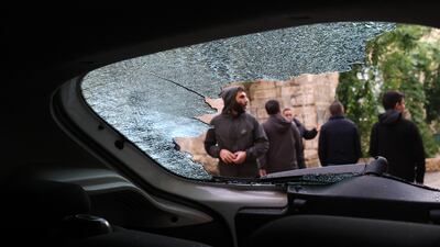 Palestinians examine a damaged vehicle after an Israeli raid in the occupied West Bank city of Nablus. EPA