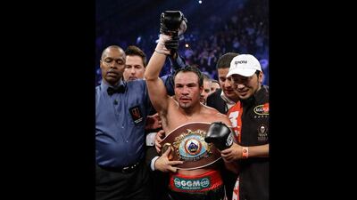 Juan Manuel Marquez wears the WBO world welterweight belt as his fist is raised by referee Kenny Bayless after his sixth round knockout of Manny Pacquiao. Julie Jacobson / AP Photo