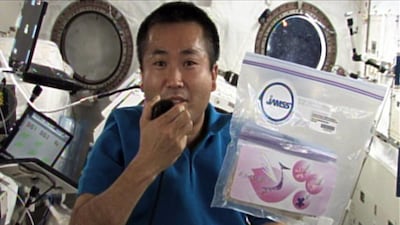 This Jaxa handout picture taken on April 13, 2009 shows Japanese astronaut Koichi Wakata holding the pack of cherry seeds in the International Space Station. AFP / JAXA