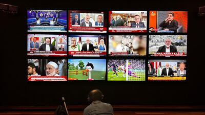 A person watches the news on multiple TV screens, most of them announcing the killing of senior Hamas leader Ismail Haniyeh, in Istanbul, Turkey. Reuters