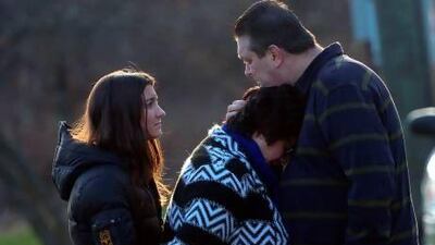 TOPSHOTS A couple and their daughter grieve after paying tribute to the victims of an elementary school shooting in Newtown, Connecticut, on December 15, 2012. A young gunman slaughtered 20 small children and six teachers on December 14 after walking into a school in an idyllic Connecticut town wielding at least two sophisticated firearms. AFP PHOTO/Emmanuel DUNAND *** Local Caption *** 111675-01-08.jpg