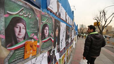 An Iranian man walks past electoral posters in Tehran. AFP