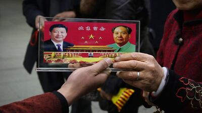 A souvenir displays an image of Chinese leader Xi Jinping, left, and Mao Zedong. Feng Li / Getty Images