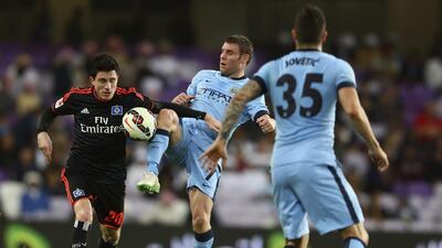 James Miller of Manchester city competes for the ball with Sven Mende of Hamburg during their friendly match in Al Ain on Wednesday. Francois Nel / Getty Images