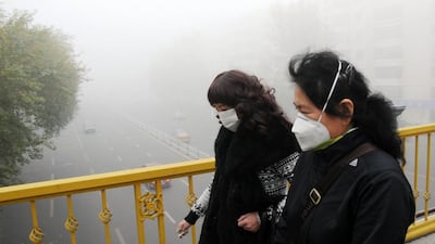 Pedestrians wearing masks walk along a road as heavy smog engulfs the city of Harbin on October 21. Expressways, schools and an airport remain closed as heavy smog continues to disrupt northeast China. Getty Images via ChinaFotoPress